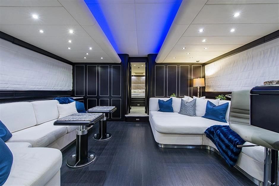 Dark-paneled salon with white seating and cobalt accents on Coal Blooded